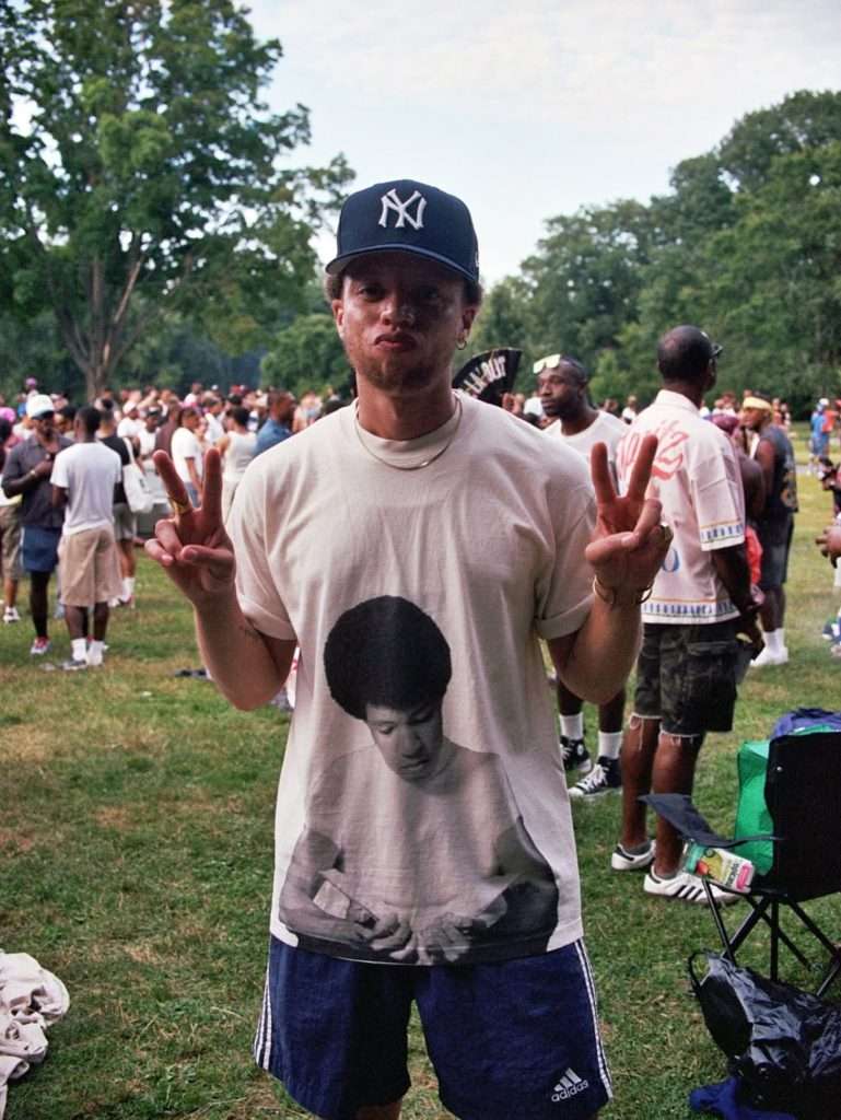 Najee Omar flashing peace signs in a crowd at Pride in the Park, shot on 35mm film